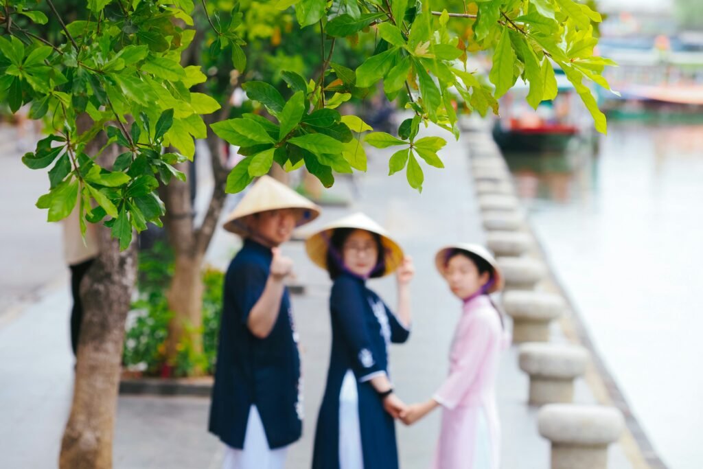 Áo dài et chapeaux coniques au bord d’un canal