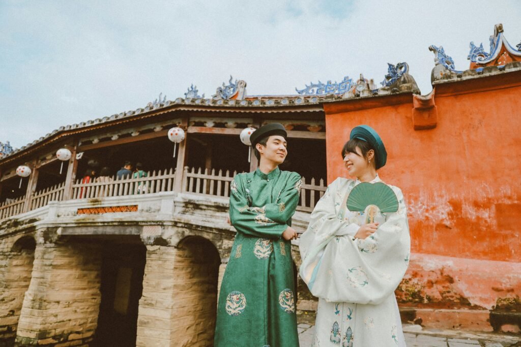 Couple en tenue traditionnelle devant un pont ancien