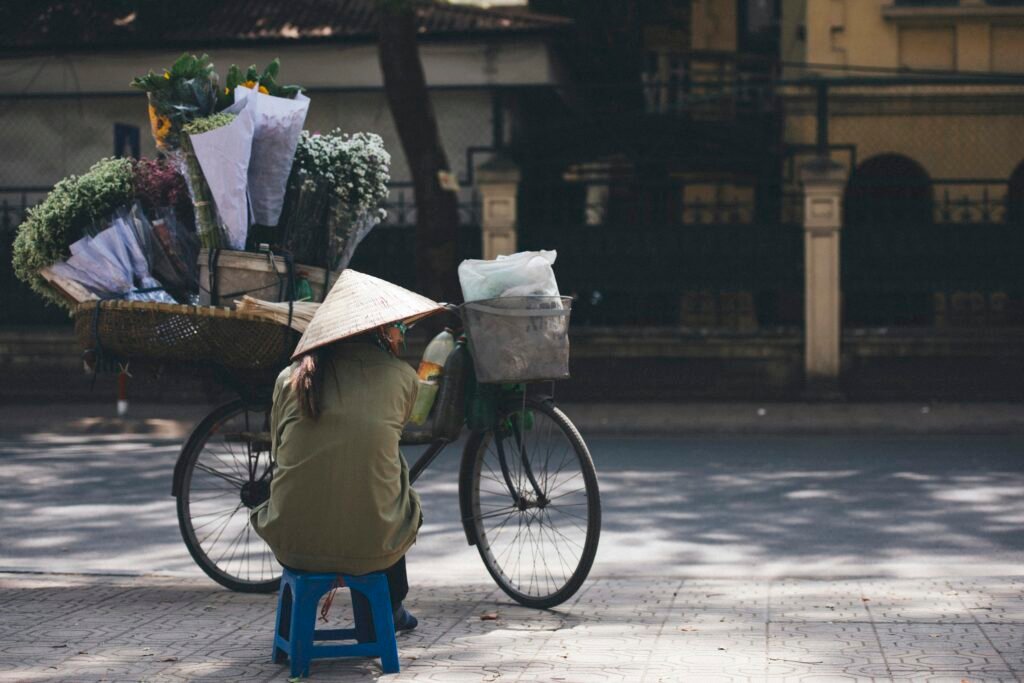 Femme à vélo au chapeau conique